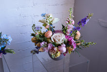 Load image into Gallery viewer, An arrangement of various flowers in a vase, featuring shades of pink, purple, white, and green.
